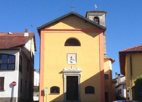 a yellow church with a cross on the top of it at Contempora Apartments - Ca' Brenta Fresco in San Fedele Intelvi
