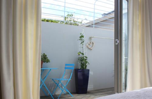 a room with a window and a blue chair at Himmelblau Boutique Bed and Breakfast in Cape Town