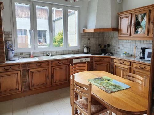 a kitchen with wooden cabinets and a wooden table at Gîte Le Bois d Argonne in Le Vieil-Dampierre