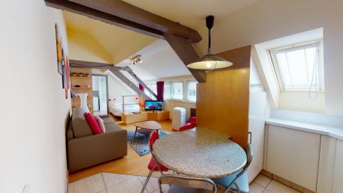 un salon avec une table et des chaises dans une pièce dans l'établissement Studio Pelletiers, 4 personnes – City center, à Strasbourg