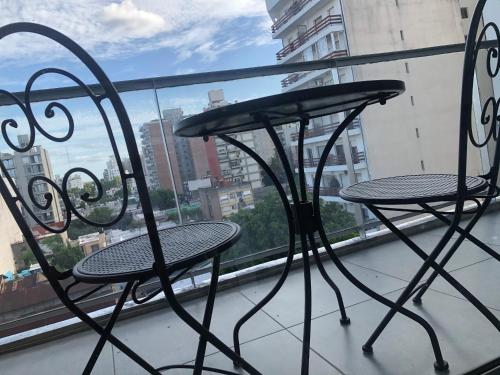 a pair of chairs and a table on a balcony at Cálido y Moderno Departamento in Rosario