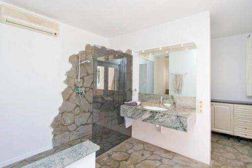a bathroom with a stone shower and a sink at Villa-Tauro Leyh in Mogán