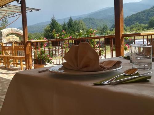 Pensiunea Casa Luanna في Drăguş: طاولة مع صحن مع منديل وكوب