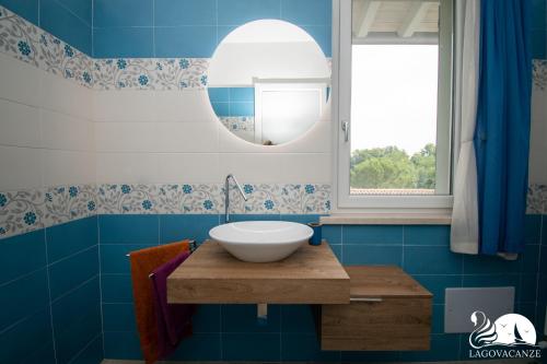 a bathroom with a bowl sink and a mirror at Villa Bocciolo del Garda in Manerba del Garda