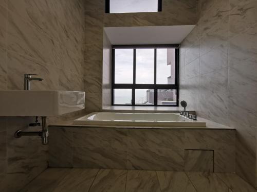a bathroom with a bath tub and a window at Thermospace Imperio A-25-10 Melaka City in Malacca