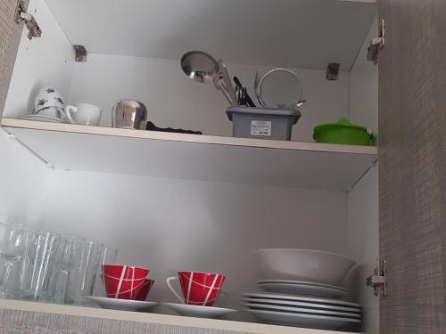 a shelf with plates and cups on it at Eirini's Apartment in Missolonghi