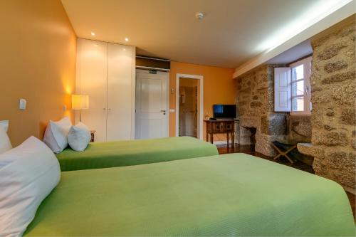 a hotel room with two beds and a fireplace at Casa de Campo Monte Abades in Terras de Bouro