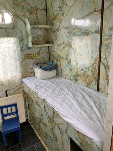 uma cama num quarto com uma parede de pedra em Vintage, Circus Holiday Home em Mablethorpe