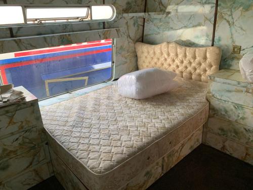 uma cama num trailer com uma almofada em Vintage, Circus Holiday Home em Mablethorpe