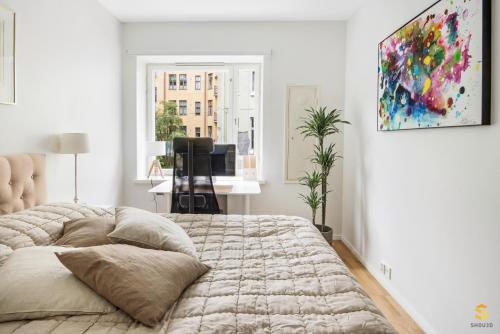 a white bedroom with a large bed and a window at WeHost Tarkk'ampujankatu in Helsinki