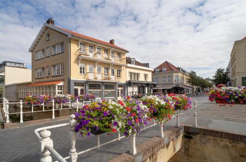 una calle con flores en una ciudad con edificios en De Kei Luxe apartment Valkenburg, en Valkenburg