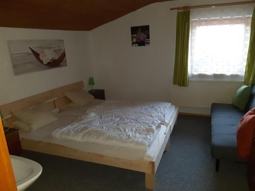 um quarto com uma cama, um sofá e uma janela em Haus Bergfrieden em Achenkirch