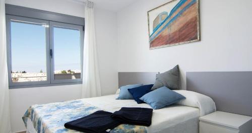 1 dormitorio con 1 cama con 2 toallas en Apartamentos Conil Park, en Conil de la Frontera