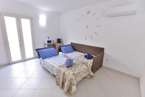 a bedroom with a bed and a table and a clock at IzzHome New One in Pula