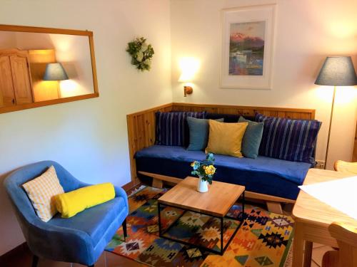 a living room with a blue couch and a table at Appartements im Park in Krumpendorf am Wörthersee