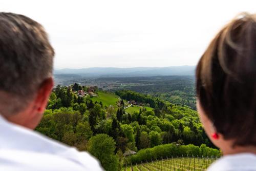 two people standing on top of a hill looking at a valley at Helgas Ferienwohnung in Gleinstätten