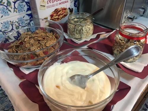 een tafel vol met schalen yoghurt en granola bij Residencial Celeste in Águeda