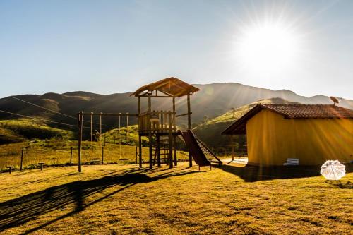 um parque infantil com escorrega e um edifício em Refúgio Pé da Serra - Chalés em São Roque de Minas