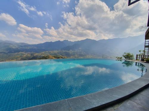 a large swimming pool with mountains in the background at Sapa Clay House - Mountain Retreat in Sa Pa