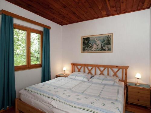 Schlafzimmer mit einem großen Bett und blauen Vorhängen in der Unterkunft Chalet Monika in Sankt Koloman