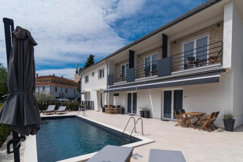 a swimming pool in front of a building at CURICTA Design Apartments in Krk