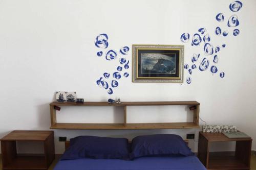 a bedroom with a bed and blue plates on the wall at Casa Azzurra in Conca Specchiulla