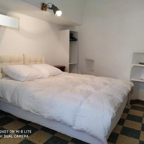 une chambre avec un grand lit blanc avec des draps blancs dans l'établissement La ferme Ranc - gite le cosy, à Gagnières