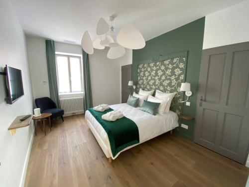 a bedroom with a green and white bed and a window at Le Charles V in Meursault