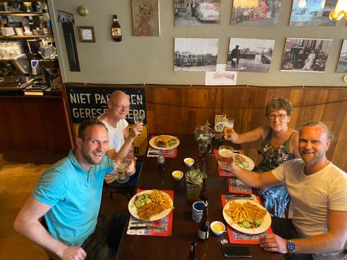 a group of people sitting at a table with plates of food at Hotel-Eetcafé d'Olde Heerd in Balkbrug