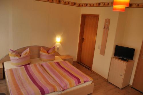 a bedroom with a bed with a colorful striped blanket at Günstiges Doppelzimmer Sächsische Schweiz in Mittelndorf