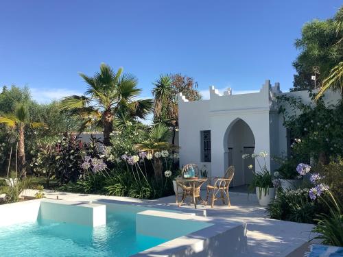 a house with a swimming pool and a table and chairs at Kasbah Andaluz guest house in Chiclana de la Frontera