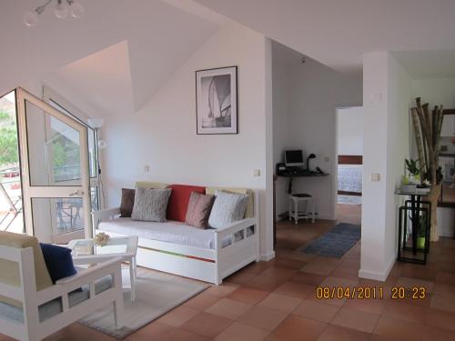 a living room with a white couch and chairs at Penthouse Marina Sol in Madalena do Mar