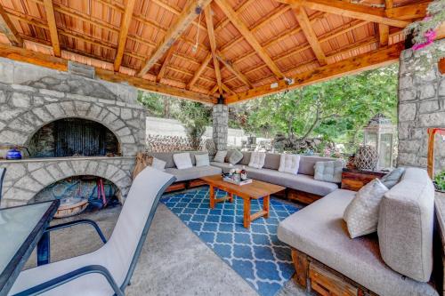 an outdoor living room with a stone fireplace at Apartments Pelle in Tivat