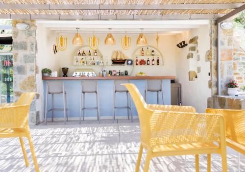a bar in a restaurant with yellow chairs at Afentiko Pigadi in Methoni