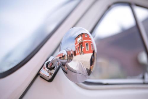 Guest House Bella Onda في تيسّيرا: مرآة جانبية للسيارة مع انعكاس للمنزل