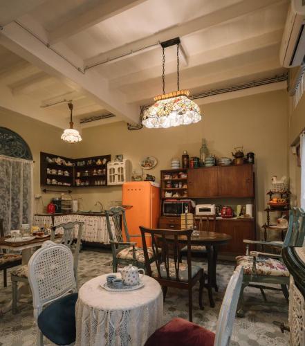 a kitchen with tables and chairs and a refrigerator at Lhong Yaowarat hostel in Bangkok