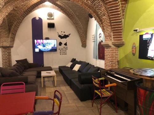 a living room with a couch and a piano at Antwerp City Hostel in Antwerp