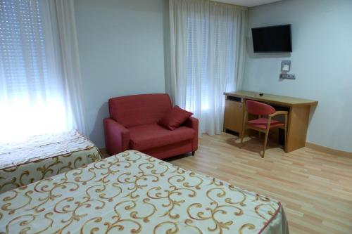 シンソ・デ・リミアにあるHotel Xinzoのベッド、椅子、デスクが備わる客室です。