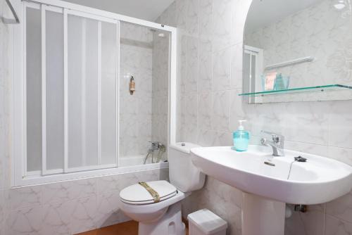 a white bathroom with a toilet and a sink at Casa Rural Areano in Escoriaza