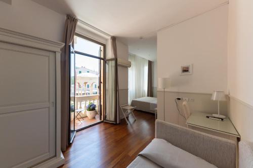 una sala de estar con sofá y una habitación con ventana en Miramare Hotel en Rapallo