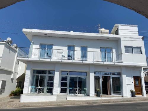 a white building with a balcony on a street at ElleNapa Apts & Studios in Ayia Napa