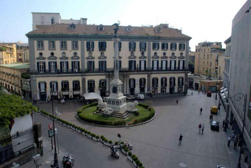 un gran edificio con una estatua en medio de una calle en Napoliday, en Nápoles