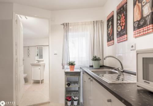 Il comprend une cuisine blanche avec un évier et une salle de bains. dans l'établissement InLoveApartments - Typical Portuguese Tiles, à Lisbonne