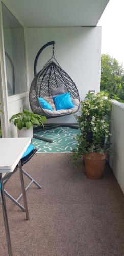 a swing on a balcony with pillows and plants at Grossdorf Ferienwohnung Waldsuite im Harz in Hahnenklee-Bockswiese