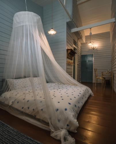 a bed with a mosquito net in a room at Lhong Yaowarat hostel in Bangkok