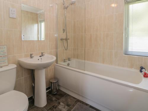 a bathroom with a sink and a tub and a toilet at Jonstone Pines in Scarborough