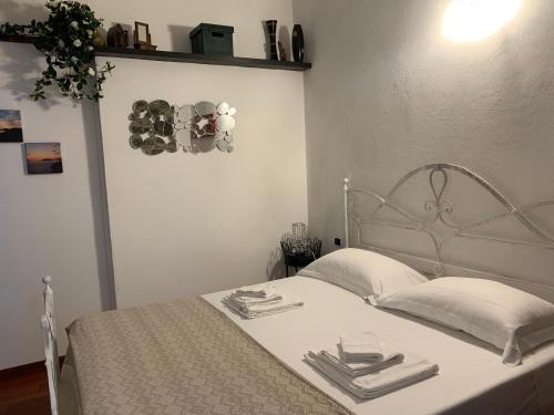 - une chambre blanche dotée d'un lit avec des draps et des oreillers blancs dans l'établissement Il Giardino Segreto, à Tellaro