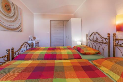 a bedroom with two beds with colorful blankets at Apartments Apartim Piran in Piran