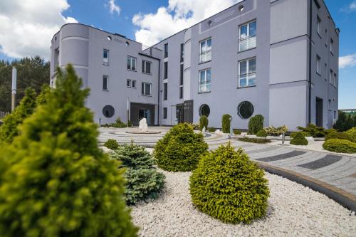 un edificio con arbustos delante de él en Resident Rene, en Ustka