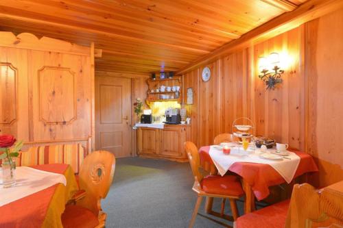 a dining room with two tables and a kitchen at Ferienhaus AB in Söll